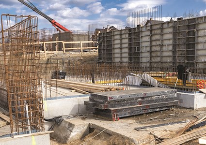 Construction site with foundation work underway in an urban area