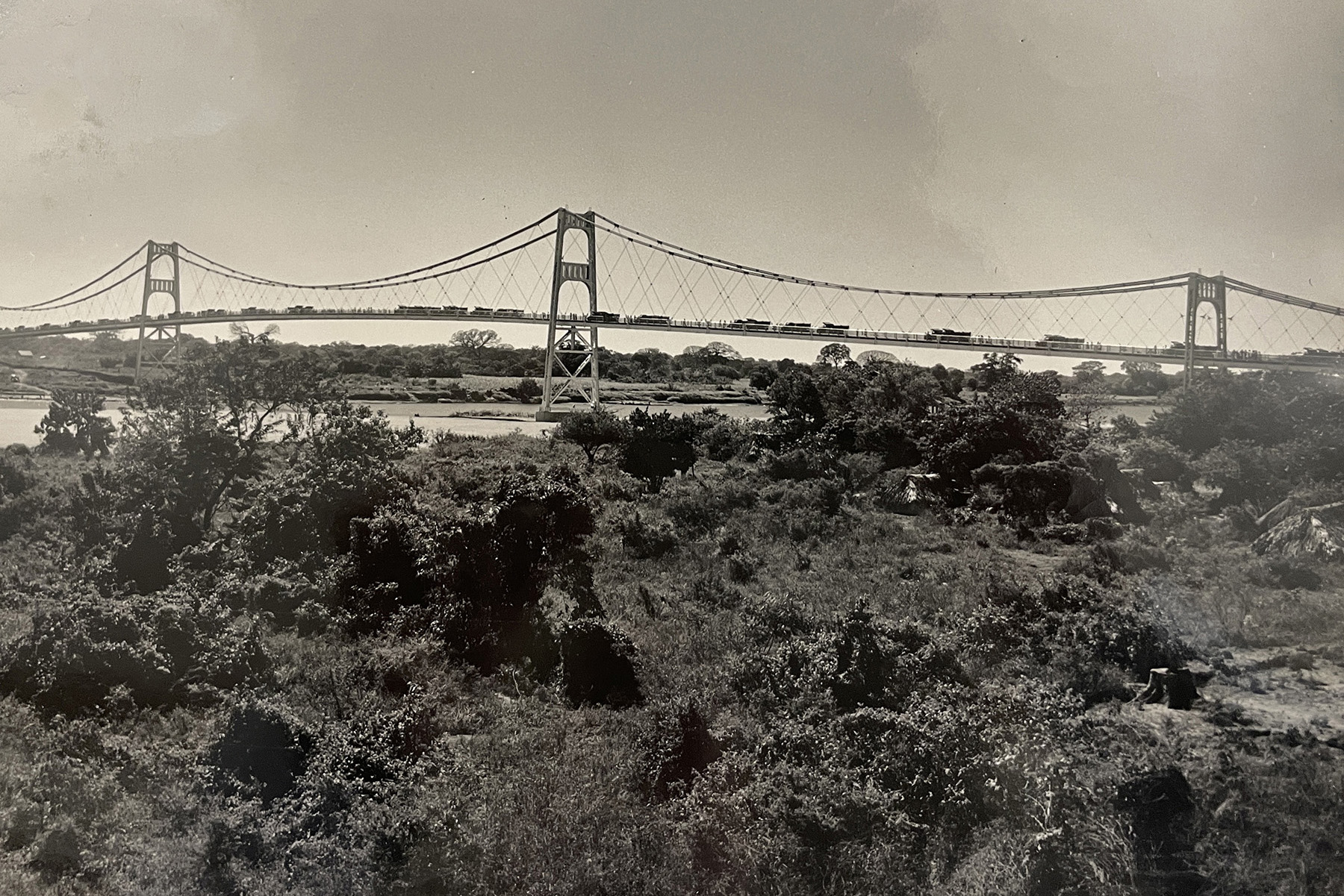 Sepia-toned photo shows a cable-stayed bridge that spans a body of water. 
