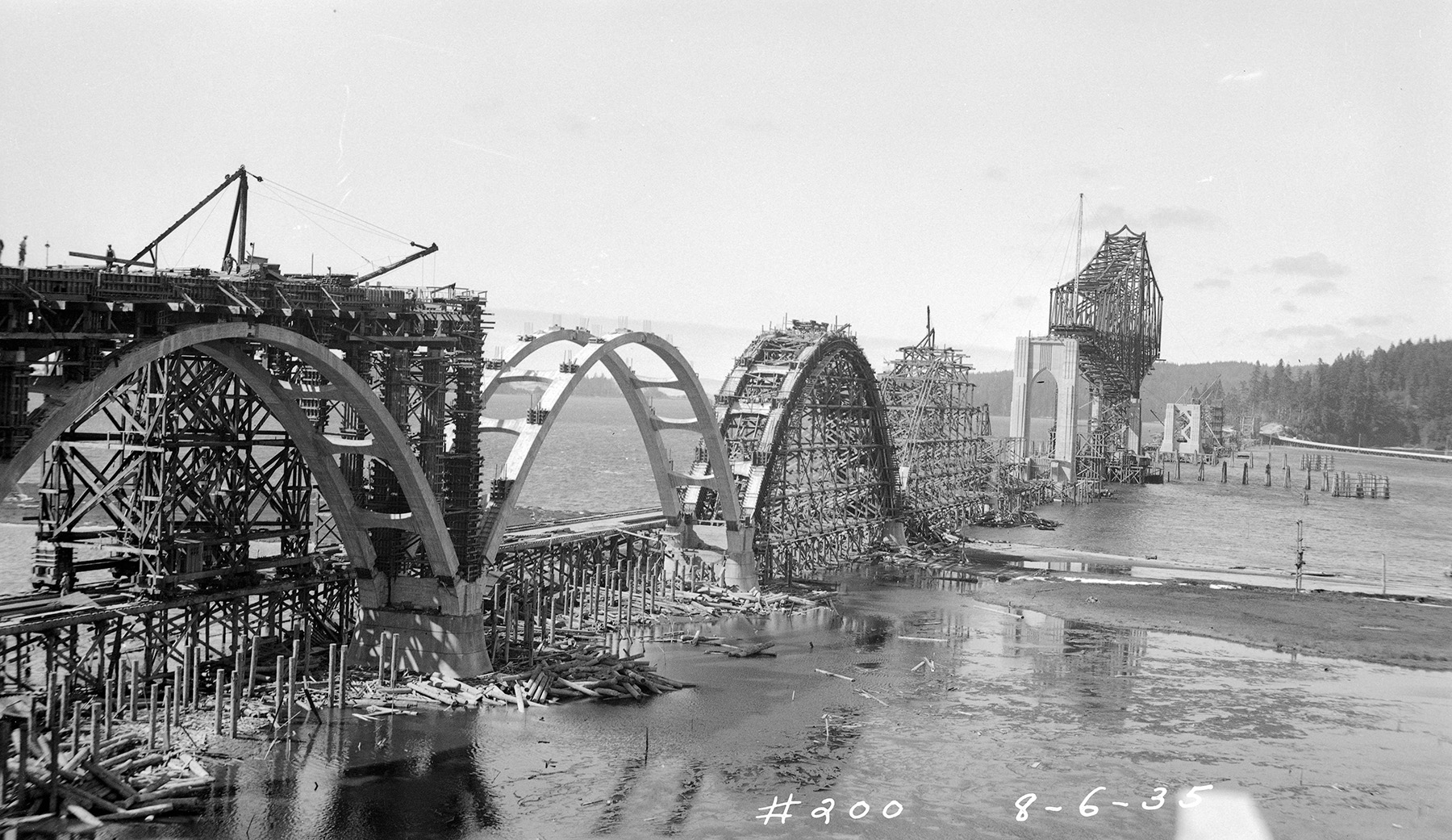 The construction of a reinforced-concrete arch bridge. The photo shows four arches and the roadway under construction. 