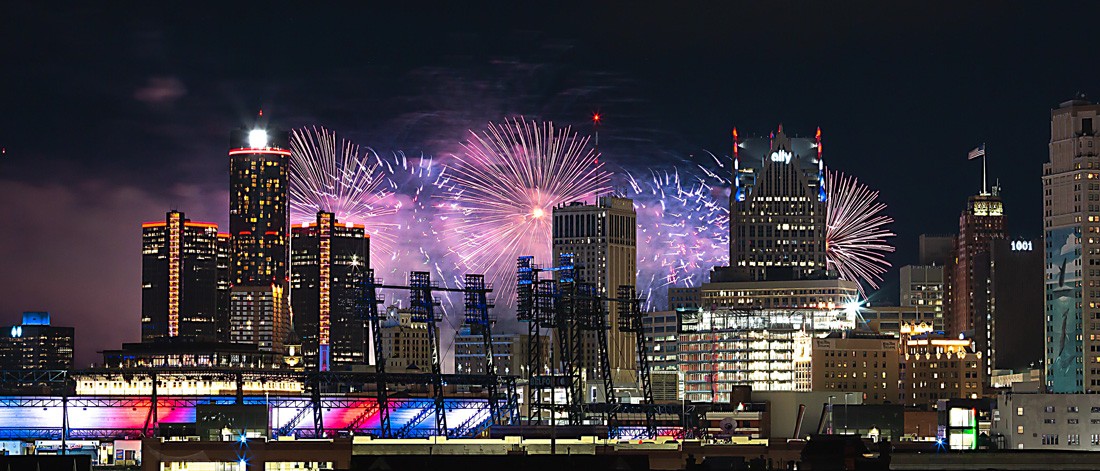 Detroit skyline at night with fireworks in the background.