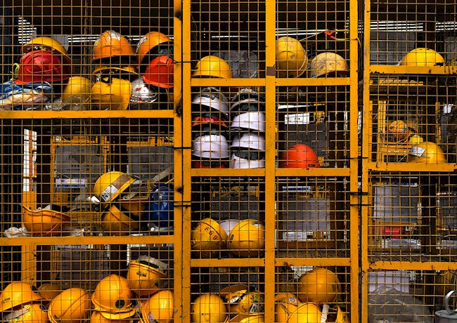 HARDHATS IN CAGE (Photo by Pop & Zebra on Unsplash)